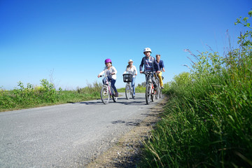 Happy family riding bikes on week-end in countryside