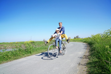Father and daughter having fun riding bike together