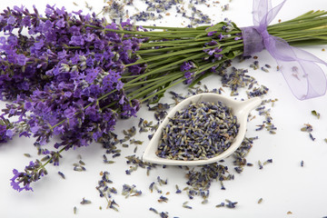 Studio shot of fresh lavender flower bouquet with a purple ribbon, over white background.