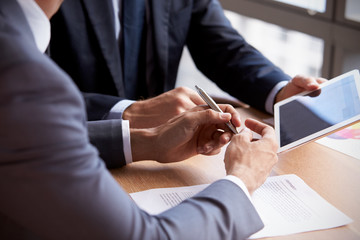 Close Up Of Businessmen Using Digital Tablet In Meeting