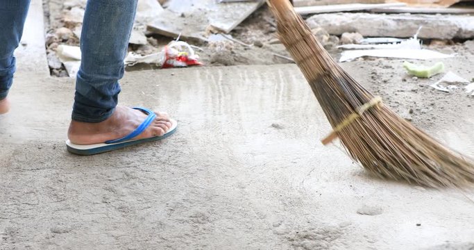 Man sweeping ground with a broom