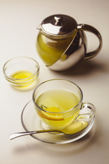 Herbal mint tea in a glass cup with lemon, the teapot and honey