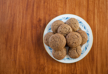 a pile of molasses cookies piled onto a vintage porcelain plate on wooden table