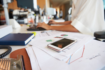 Close Up Of Phone And Paperwork On Businesswomans Desk