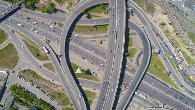 Aerial slow-mo footage. Flying over road junction zoom in with counter clockwise rotate