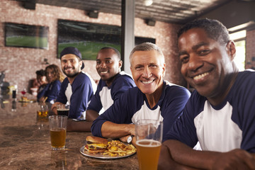 Portrait Of Male Friends At Counter In Sports Bar