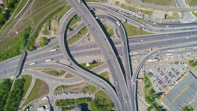 Aerial slow-mo footage. Flying over road junction with counter clockwise rotate