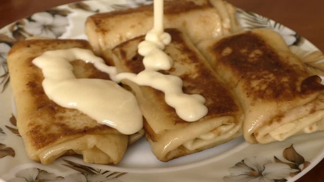 On the plate is four pancakes. Pancakes pour with condensed milk