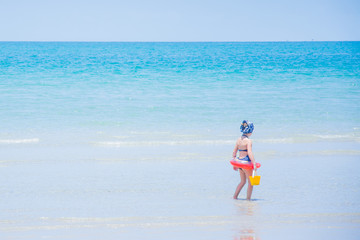 Fototapeta na wymiar little girl walking on the beach summer vacation