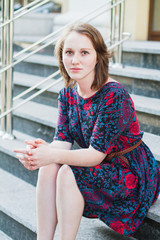 Young girl sitting on the stairs alone.