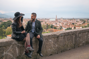 Fototapeta premium Young modern hipster couple in love. Deep moment of a love story with a vintage look, city view in the background. 