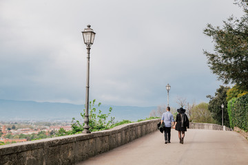 Young couple in love walking together hand by hand, city view in the background. 