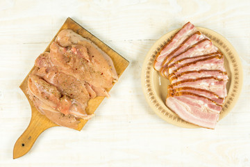 Raw chicken breasts and bacon ready for barbecue