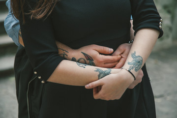 Close-up of a young tattooed couple holding hands