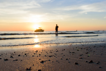 Fototapeta premium women shadow with man and boat shadow near light sunset on the beach