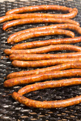 Flat lay grill with barbecue sausages on the fire