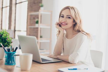 Happy pretty cute woman sitting at the table working with computer