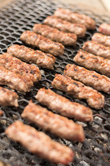 Grilling minced meat kebabs on the barbecue with selective focus