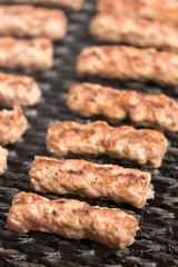 Grilling minced meat kebabs on the barbecue with selective focus