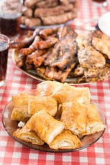Cheese pie served on the plate with meat in the background