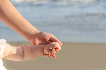 Mother is holding child's hand