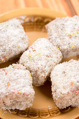 Chocolate cookies with coconut served on the plate over wooden background