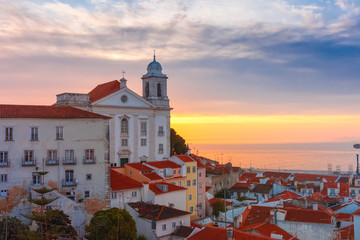 Fototapeta premium View of Alfama, the oldest district of the Old Town, with Church of Saint Stephen at cloudy sunrise, Lisbon, Portugal