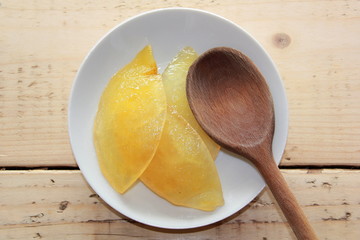 Sliced Lemon on a White plate with a wooden spoon
