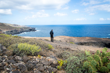 One person standing in beautiful landscape with cliffs and sea in Gran Canaria, Canary Islands -...