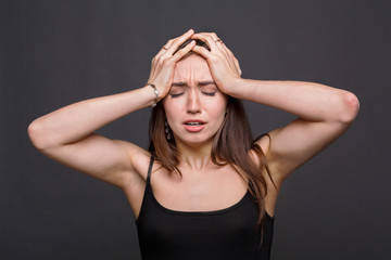 Emotional stressed woman portrait on dark background