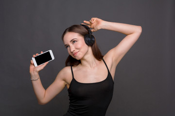 Woman listen to music in earphones, studio shot