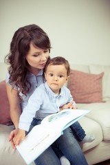 Young mother reads a book with a young son. Cute little boy and his mom.