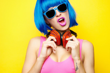 Beautiful young sexy girl dj in blue wig blue sunglasses and pink bathing suit having fun and...