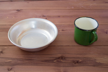 Aluminum dishes for camping on a wooden background.