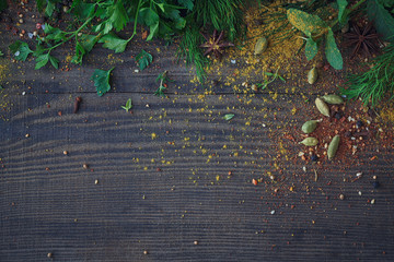 Mix of fresh herbs and spices assortment on wooden background.