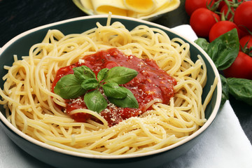 Plate of delicious spaghetti Bolognaise or Bolognese with savory minced beef and tomato sauce garnished with parmesan cheese and basil
