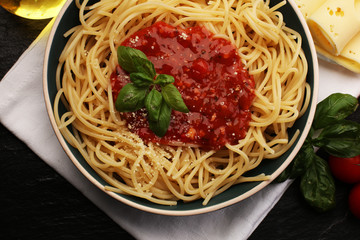 Plate of delicious spaghetti Bolognaise or Bolognese with savory minced beef and tomato sauce garnished with parmesan cheese and basil