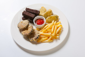 Fresh beer snacks assortment on a white plate. French fries, croutons and eggplant