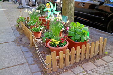 Blumenbeet an Stadt-Baum mit Windmühle