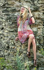 Girl in a stylized sundress near stone ruins