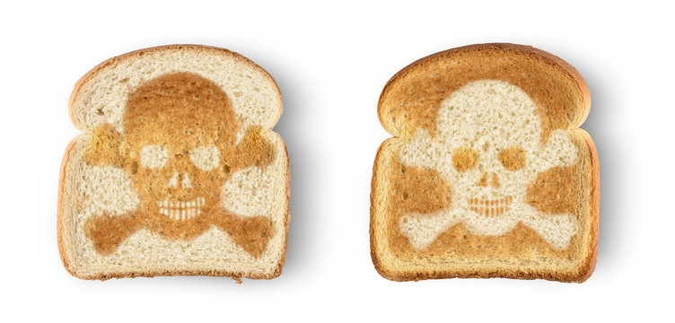 Burnt toast with image of skull and crossbones. Isolated on white