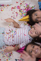 Obraz na płótnie Canvas kids blowing confetti while lying on the floor