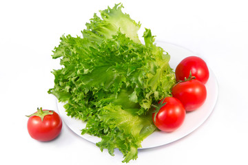 Red tomatoes and green lettuce on white background