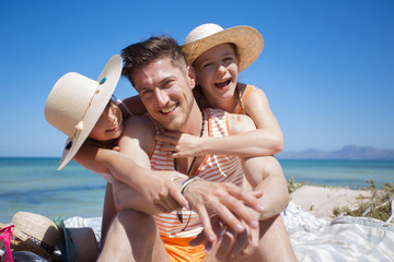 Vater mit Töchtern am Meer