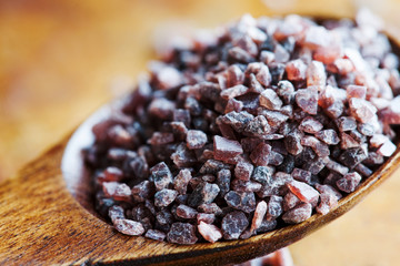 Black salt condiment macro view. Himalayan Kala Namak rock saline sodium chloride pink crystal in...