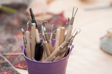 The tool for making ceramic products is in a small bucket on the table