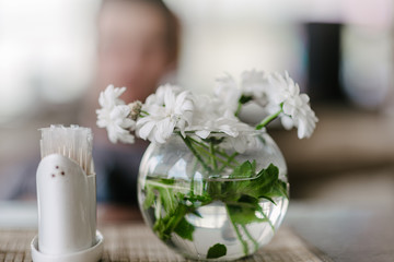 Fototapeta na wymiar Vase with flowers in a cafe