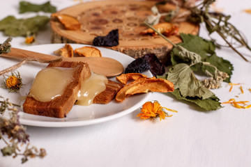 Apple pastillas, honey, dried fruit on a white table