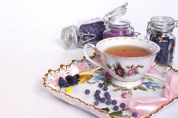 Sugar from flowers of a violet with a cup of tea