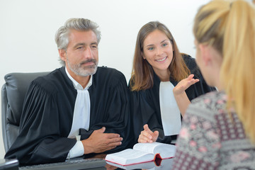 Legal workers in robes talking to client